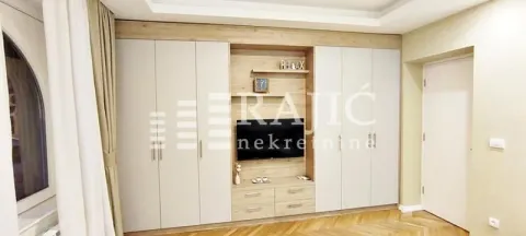 A furnished bedroom with built-in closets and a television. - image 4