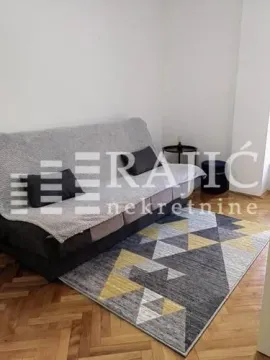 Living room with a sofa and rug. - image 14