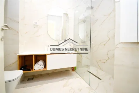Modernly equipped bathroom with a walk-in shower and marble-look tiles. - image 6