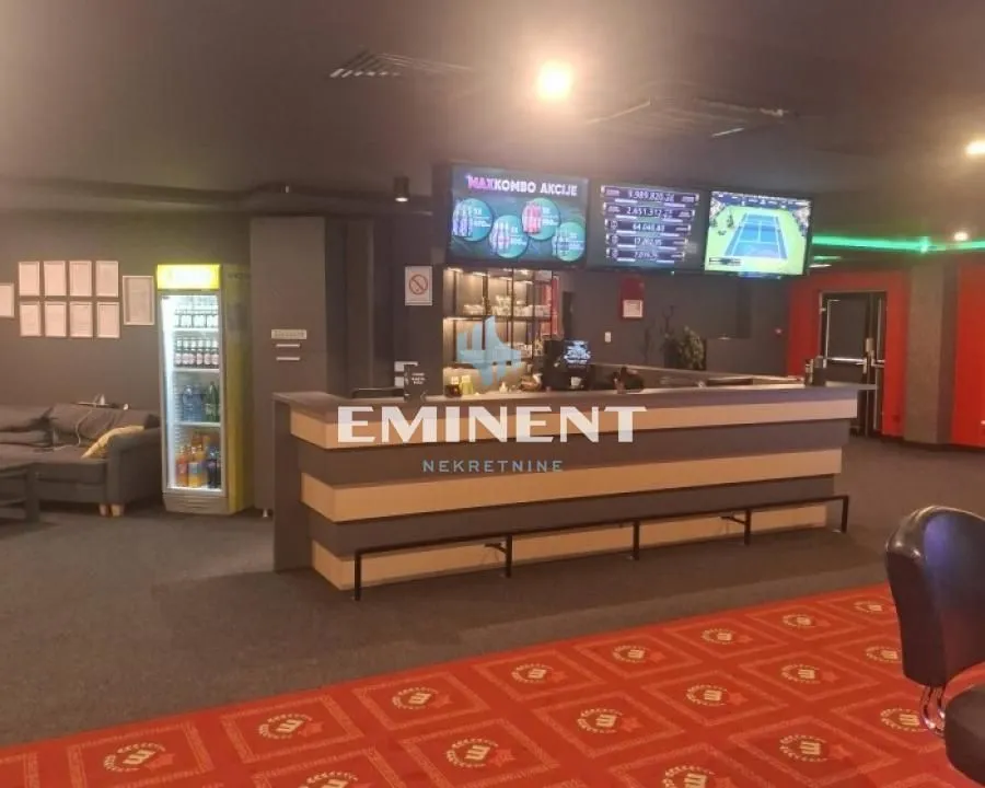 Interior of the commercial space with a counter and wall screens.