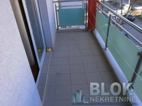 Small tiled balcony with metal railing and glass panels. - image 9