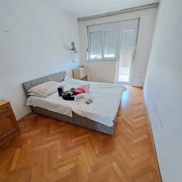 Spavaća soba sa bračnim krevetom, parketom i izlazom na terasu. - image 7