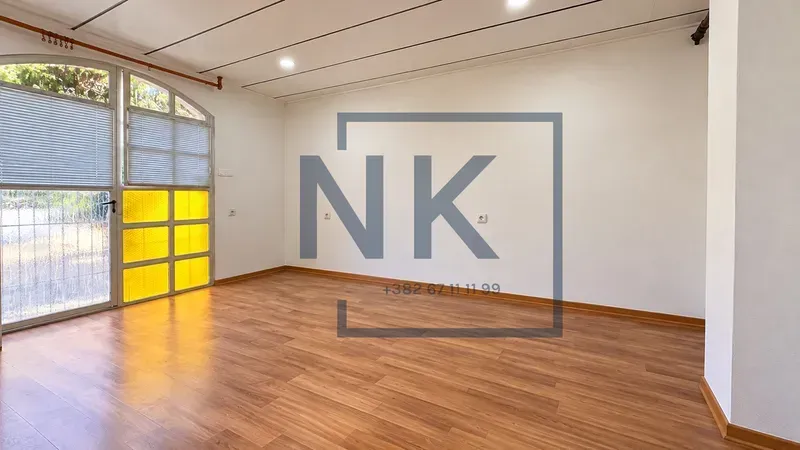 Empty room with laminate flooring and a glass door.
