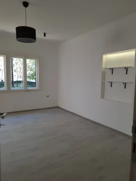 Empty bright room with laminate flooring, white walls, and built-in shelving. - image 5