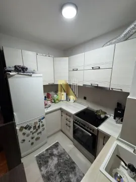 Manja kuhinja sa svetlim elementima, frižiderom i šporetom. - image 9