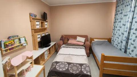 Children's bedroom with two beds and light wood furniture. - image 5