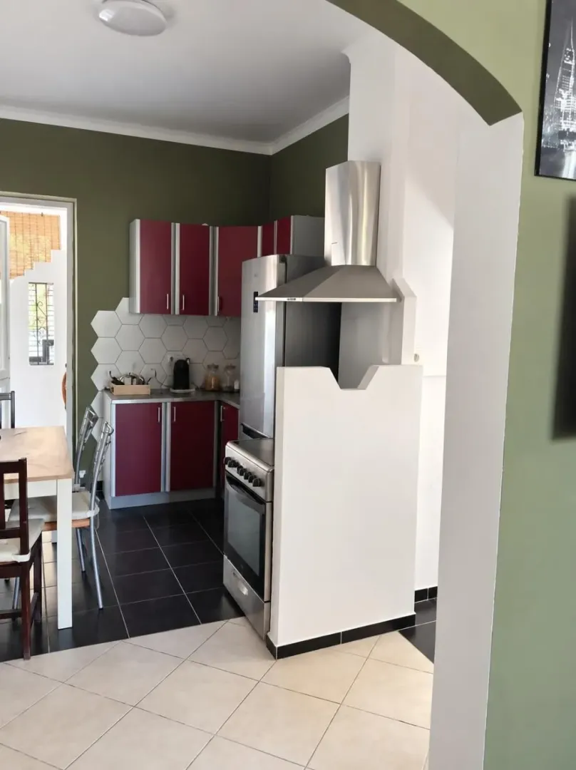Kitchen with red cabinets, dining table, and access to the terrace.