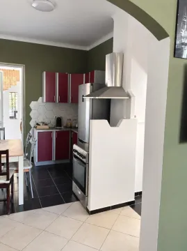 Kitchen with red cabinets, dining table, and access to the terrace. - image 5
