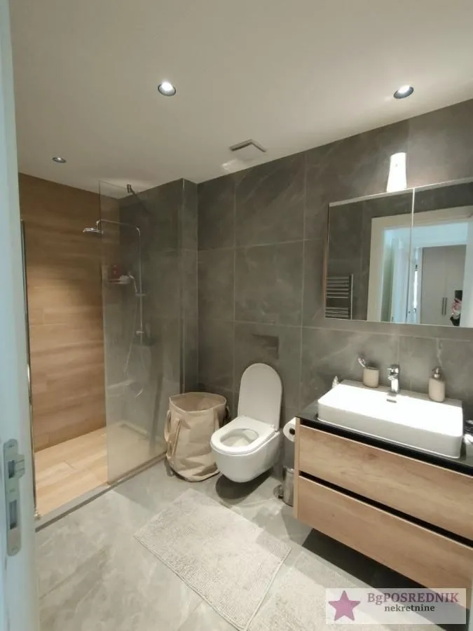 Moderno kupatilo sa tuš kabinom, umivaonikom i wc šoljom.