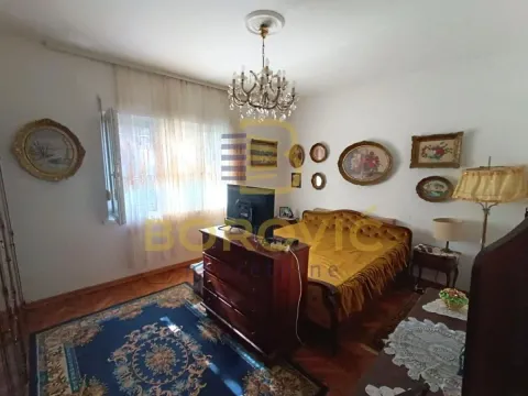 Nameštena spavaća soba sa bračnim krevetom, komodom i brojnim slikama na zidu. - image 6