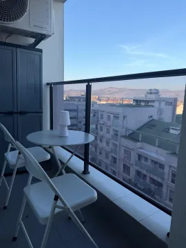 Furnished terrace with a table, chairs, and city view. - image 13