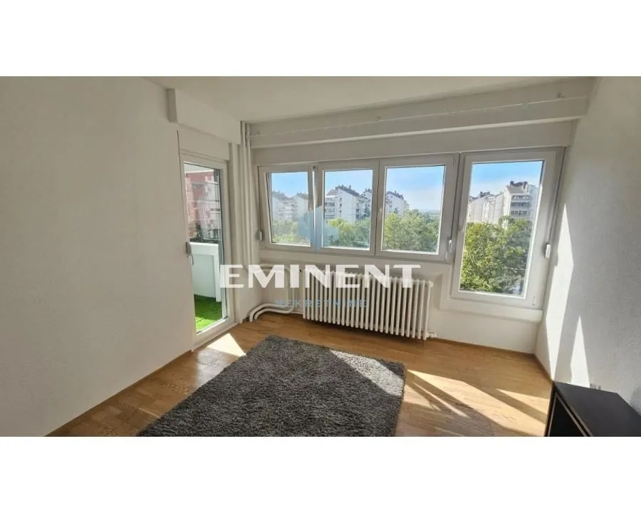 Bright living room with large windows and access to the terrace.