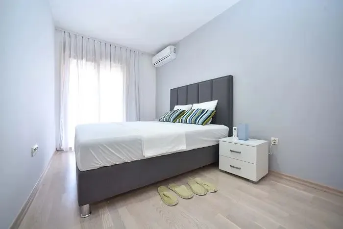 Bedroom with a double bed, nightstand, and air conditioning unit.