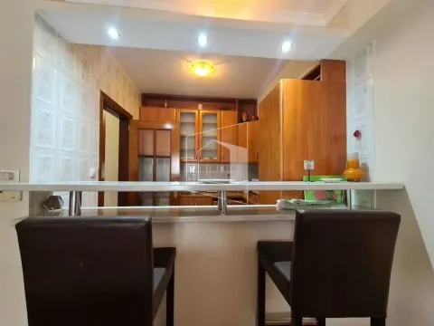 Kitchen with a bar counter and bar stools. - image 4