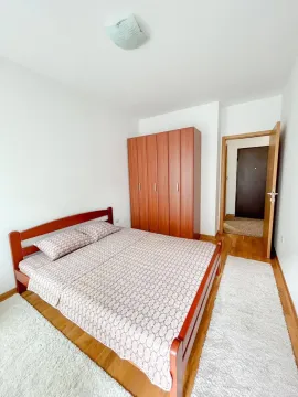 Spavaća soba sa bračnim krevetom i drvenim ormarom. - image 4