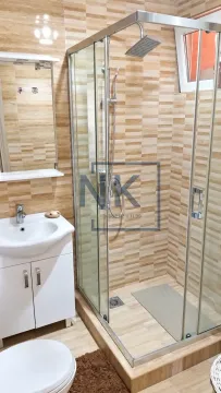 Bathroom equipped with a shower cabin, vanity with sink, and a mirror. - image 6