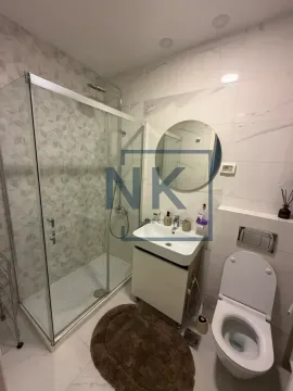 Modern bathroom with a walk-in shower, washbasin, and toilet. - image 8