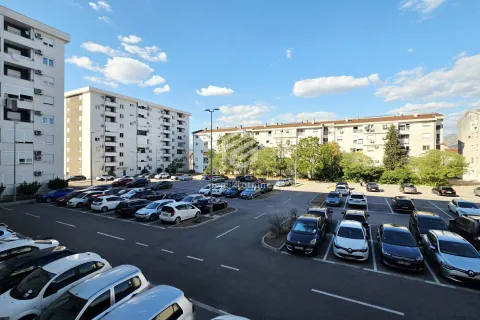 Pogled iz stana na parking i okolne stambene zgrade. - image 2