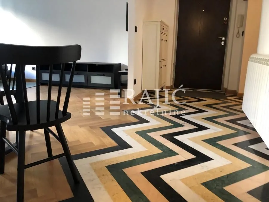 Interior of the apartment with a dining table and parquet flooring.