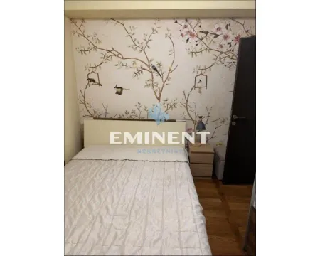 Furnished bedroom with a double bed and decorative wallpaper on the wall. - image 7