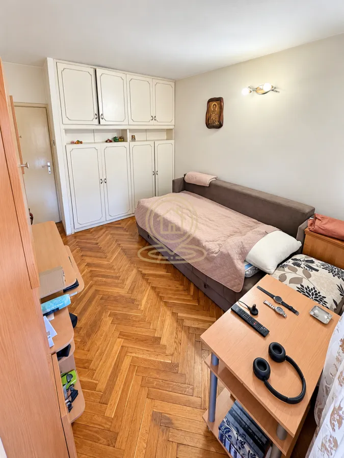 Manja spavaća soba sa krevetom na razvlačenje i ugradnim ormanom.