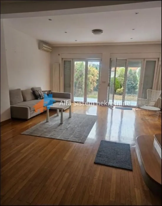 Spacious living room with a sofa set and access to the yard.