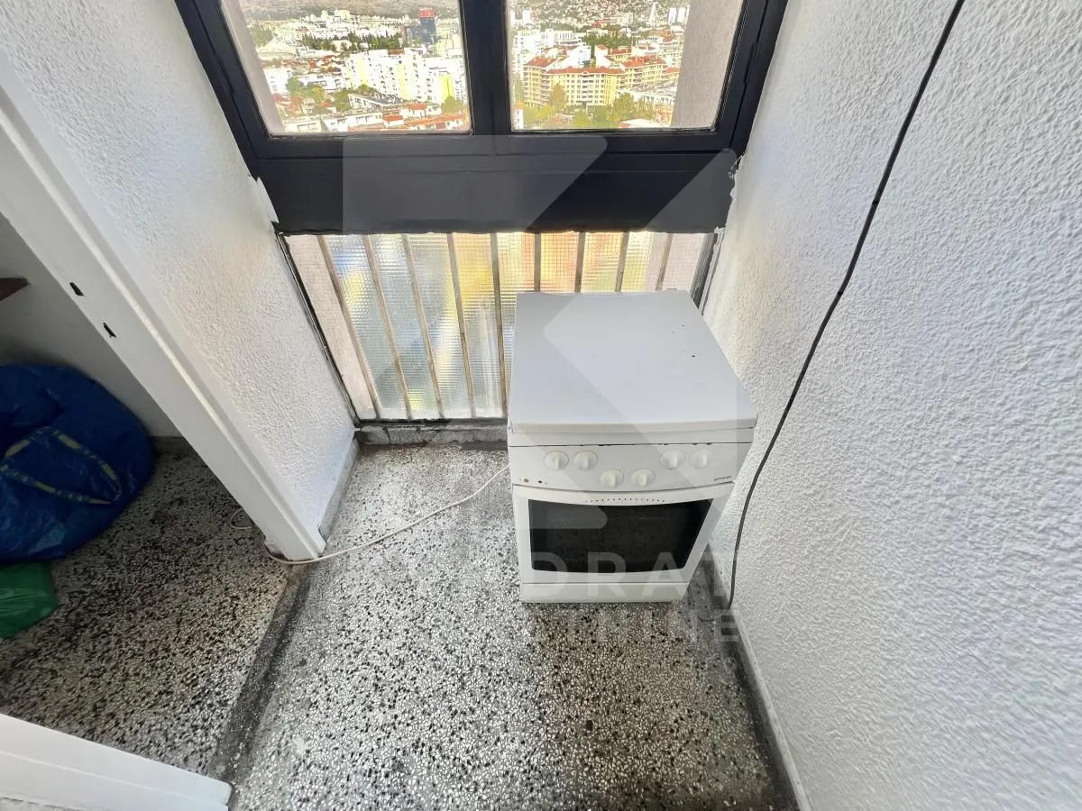 Manji balkon ili lođa sa štednjakom i pogledom na grad.
