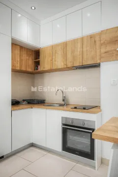 Moderna kuhinja sa bijelim elementima i drvenim detaljima. - image 11