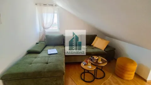 Attic living room with a green corner sofa and a small coffee table. - image 4