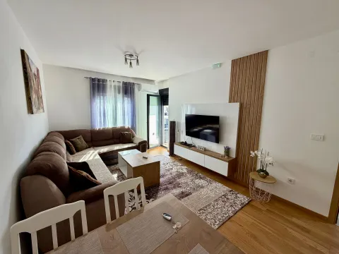 Comfortable living room with a sectional sofa, TV unit, and dining table. - image 10