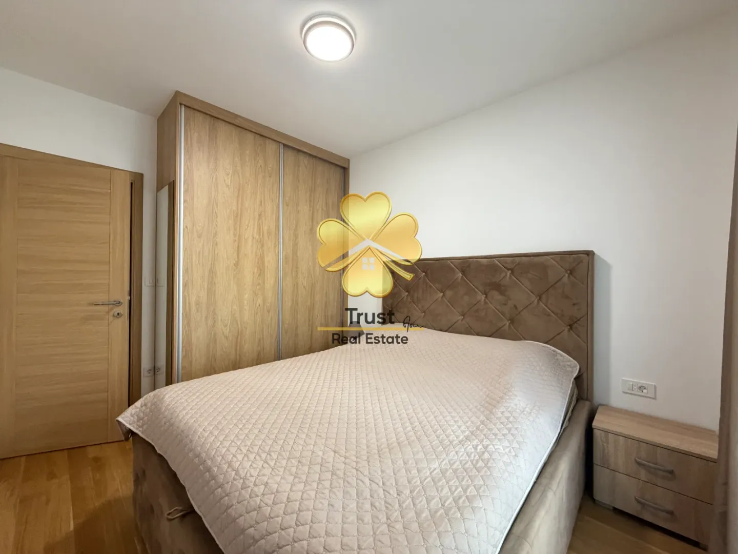 Furnished bedroom with a double bed, wardrobe, and a nightstand.