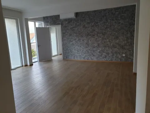 Spacious empty room with a decorative grey wall and laminate flooring. - image 6