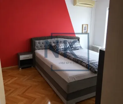 Bedroom with a double bed and a red accent wall. - image 6