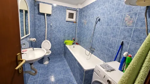 Kupatilo obloženo plavim pločicama sa kadom, umivaonikom, toaletom i veš mašinom. - image 8