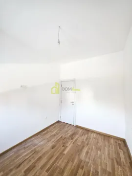 Empty room with white walls, wooden flooring, and a single door. - image 4