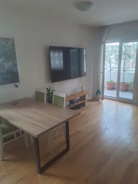 Svijetla dnevna soba sa trpezarijskim stolom, televizorom i izlazom na balkon. - image 18
