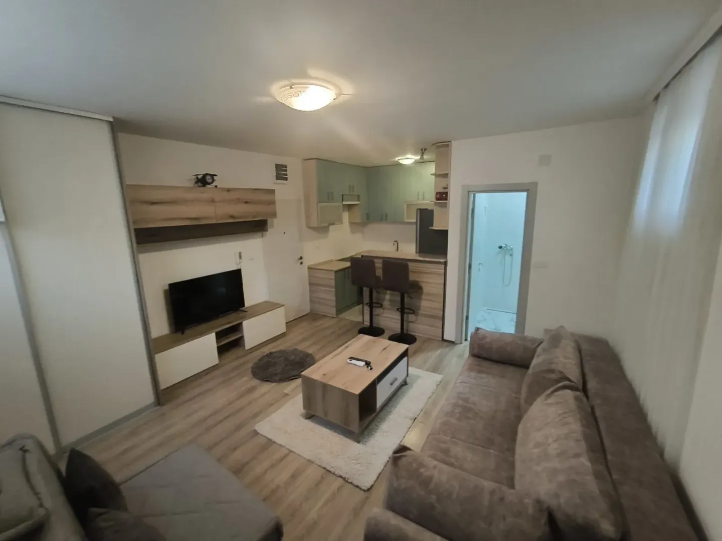 Bright open-plan living room with a kitchen and a bar.