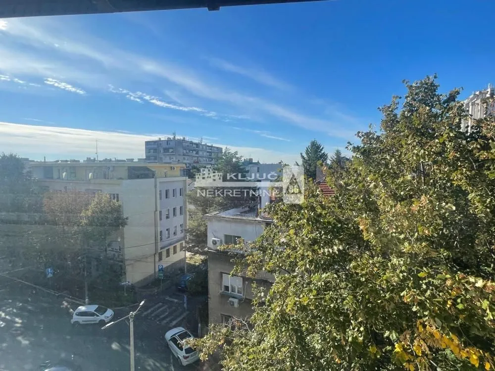 Pogled sa prozora na okolne zgrade i gradsko naselje.