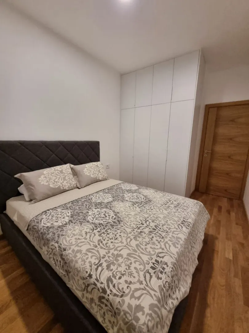 Bedroom with a double bed, built-in wardrobe, and wooden flooring.