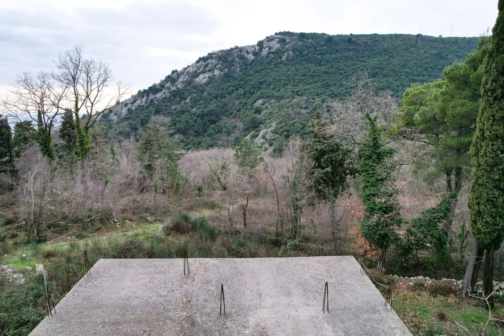 Pogled na brdo i okolnu prirodu sa betonske ploče u izgradnji.
