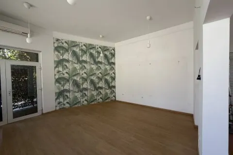 Empty room with wooden flooring and decorative wallpaper on one wall. - image 5
