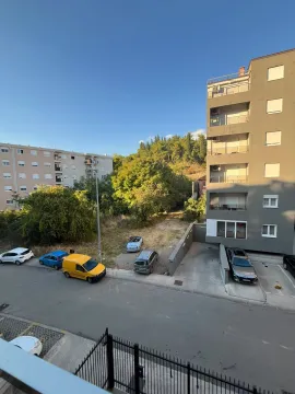 Pogled iz stana na ulicu, parking i okolne zgrade sa zelenilom. - image 5