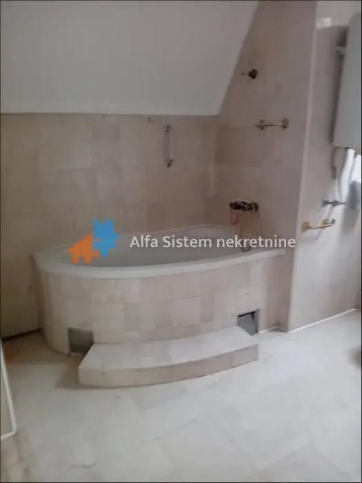 Bathroom with a built-in bathtub and ceramic tiles.