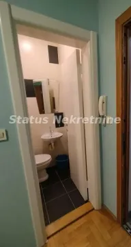 Pogled iz hodnika na manje kupatilo sa umivaonikom i šoljom. - image 4