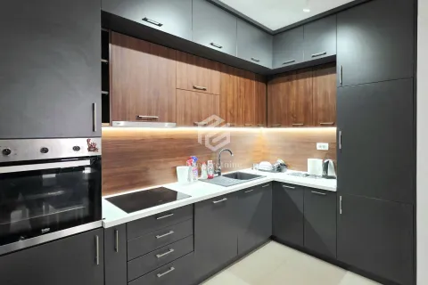 Modern corner kitchen with dark cabinets and wood details. - image 12