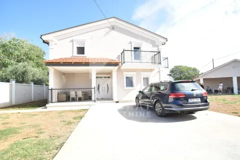 Front yard area with the house facade and a parked car. - image 2