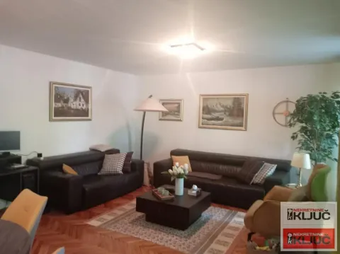 Dnevna soba sa garniturom, stočićem i slikama na zidu. - image 3