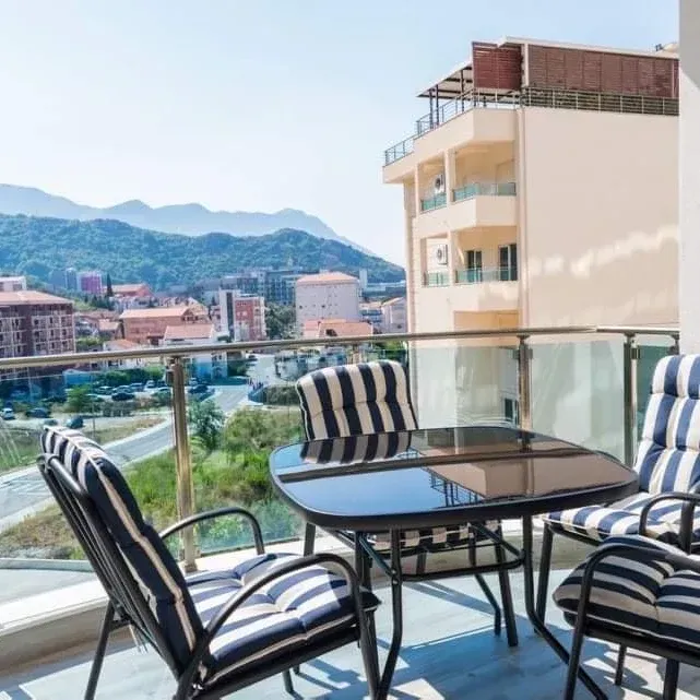 Furnished terrace with a dining table and a view of the city and surrounding mountains.
