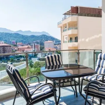 Furnished terrace with a dining table and a view of the city and surrounding mountains. - image 10