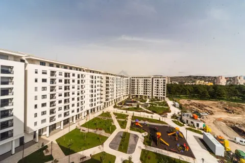 Pogled na spoljašnjost stambenog kompleksa sa uređenim dvorištem i igralištem. - image 11
